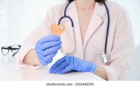 Female Young Doctor Cardiologist Holding Heart Figure In Hands,