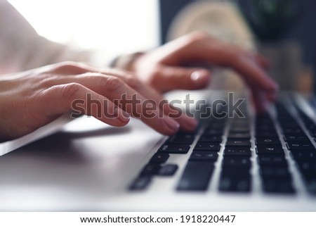 Female young hands with manicure typing text on laptop. Working with laptop at home or office. Close-up.