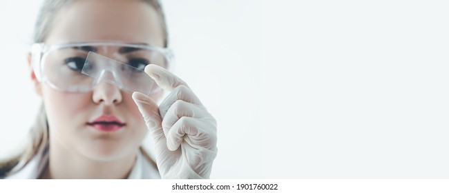 Female Young Scientist Or Doctor With Microscope Looking Vaccine COVID-19 Test Slide On White Background In Medical Laboratory