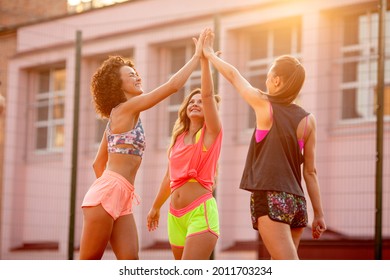 Females  basketball  players meet and give hi five on street court, on summer day. Female street basketball player in action - Powered by Shutterstock