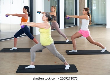 Females Of Different Ages Doing Pilates Exercises With Two Small Fitness Balls During Group Training At Gym