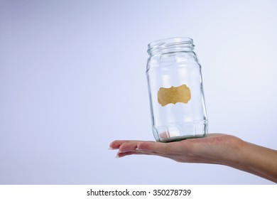 Female's Hand Holding A Empty Jar