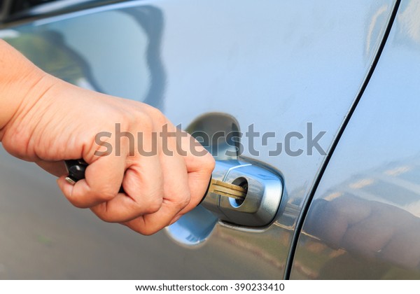 female\'s hand\
opening a car door with car\
key