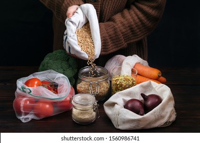 Females Hands Holding Reusable Bag Among Healthy Food In Plastic Free Packaging On Wooden Table. Zero Waste Concept. Waste Free Food Storage