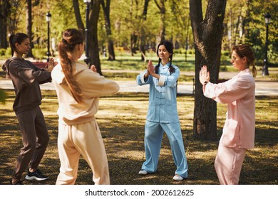 Females standing in circle and meditating in park - Powered by Shutterstock