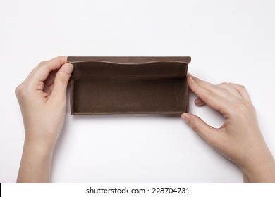 A female(woman, girl) hold a leather eye wear(glasses) case isolated white, top view.