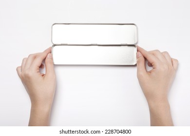 A Female(woman, Girl) Two Hands  Hold A Empty Iron(stainless) Pencil Case Isolated White, Top View.