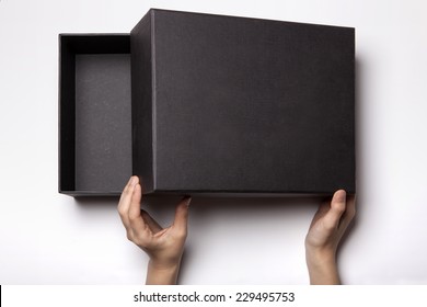 A Female(woman, Girl) Two Hands Hold And Open The Empty(blank) Black Box Isolated White, Top View At The Studio.