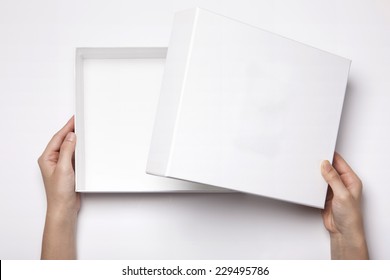 A Female(woman, Girl) Two Hands Hold And Open The Empty(blank) White Box Isolated White, Top View At The Studio.