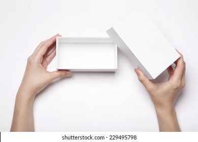 A Female(woman, Girl) Two Hands Hold And Open The Empty(blank) White Box Isolated White, Top View At The Studio.