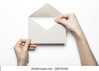 A female(woman) hand hold a grey envelope and post card isolated white at the studio. - Shutterstock ID 240701242