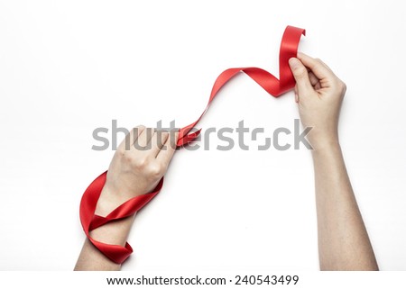 A female(woman) hand hold a red ribbon isolated white background at the studio.