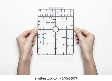 A Female(woman) Hand Hold A Trash(part, Set, Kit) Of Plastic Model(toy) Isolated White, Top View At The Studio.