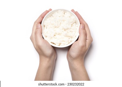 A female(woman) two hands hold a bowl with rice isolated white, top view at the studio.