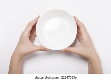 Female(woman) two hands hold a white bowl(plate)isolated white and top view. 