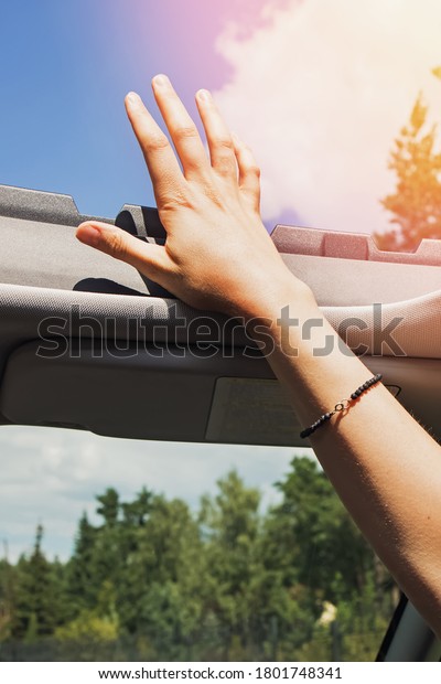Feminine hand out from open hatch of a
vehicle on sunny day. Travel lifestyle
concept