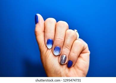 A Feminine Hand With Painted Nails In A Colorful, Hybrid Varnish
