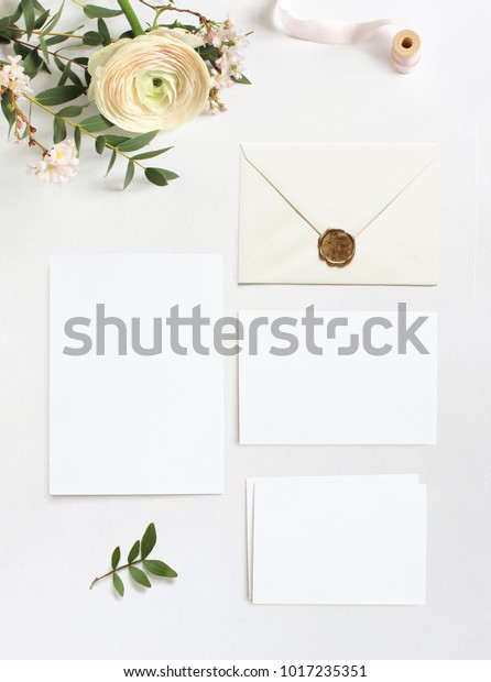 女性の結婚式 誕生日デスクトップのモックアップ 空のグリーティングカード 封筒 ユーカリの枝 ピンクの桜の花 ペルシャの蝶の花 白い表の背景 平面 上面図 の写真素材 今すぐ編集