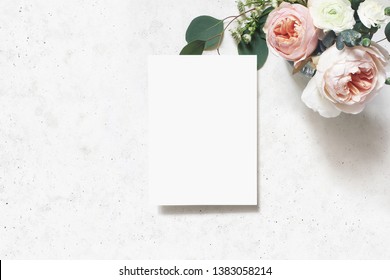 Feminine Wedding, Birthday Mock-up Scene. Blank Paper Greeting Card. Bouquet Of Blush Pink English Roses, Ranunculus Flowers And Eucalyptus Leaves. Concrete Table Background. Flat Lay, Top View.