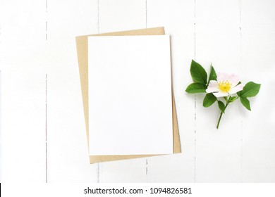 Feminine Wedding Stationery, Floral Desktop Mock-up Scene. Blank Greeting Card, Craft Envelope And Blooming Wild Rose Branch. Old White Wooden Table Background. Flat Lay, Top View. 