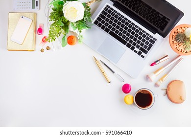 Feminine workspace border with keyboard, coffee and flowers, top view and copy space on desktop