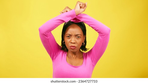 Feminist woman raises arms above head, protest NO, yellow studio background - Shutterstock ID 2364727733