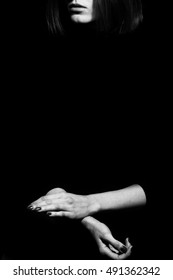Femme fatale concept. Old classic movies actress style. Close up profile portrait of gorgeous young woman with beautiful hands over black background. Black and white studio shot. Copy-space
