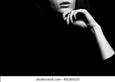 Femme fatale concept. Old classic movies actress style. Close up profile portrait of gorgeous young woman with beautiful hands over black background. Black and white studio shot Copy-space