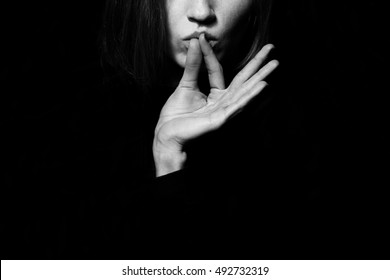 Femme fatale concept. Old classic movies actress style. Close up profile portrait of gorgeous young woman with beautiful hands over black background. Black and white studio shot. Copy-space