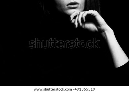 Femme fatale concept. Old classic movies actress style. Close up profile portrait of gorgeous young woman with beautiful hands over black background. Black and white studio shot Copy-space