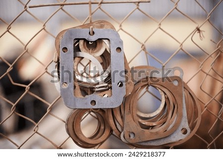 Fence, car gasket throttle and engineering in a scrap yard and mechanic equipment with vehicle industry. h.Hanging engine parts, metal and recycling with steel and copper with rust, alloy and metal