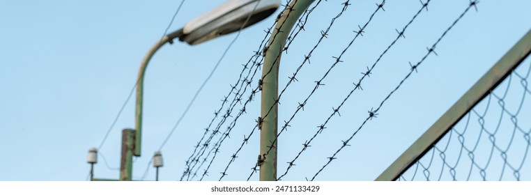 A fence covered with barbed wire to prevent trespassing