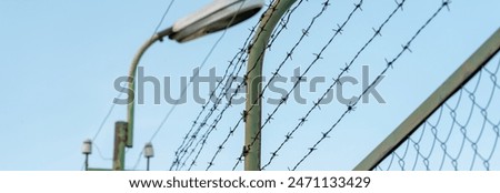 A fence covered with barbed wire to prevent trespassing
