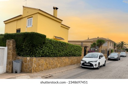 Fence of house at street with pavement road. Villa at seaside. Car parked on empty street in residential area. Private villa and luxury houses. Apartment house and home residential building with gate - Powered by Shutterstock