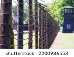 The fence is made of barbed wire and wooden poles. A camp for prisoners.