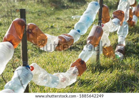 A fence made from old plastic bottles. Recycling and processing of inorganic waste.
