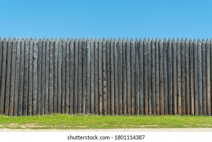 The fence is made of uncouth logs. palisade are rough and pointed to the top.  - Shutterstock ID 1801114387