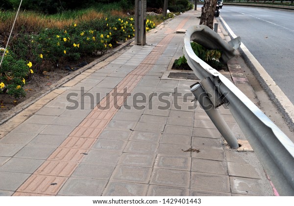 The fence on the side of\
the road in the curve of the road is distorted because of being hit\
by a car.