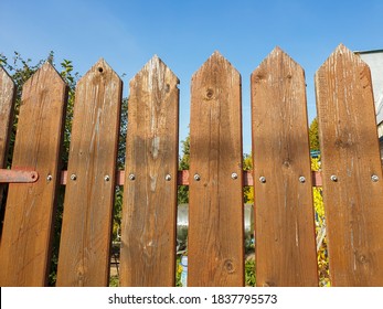 Fence palisade fence on blue sky background. Pointed logs, old wood texture. - Shutterstock ID 1837795573