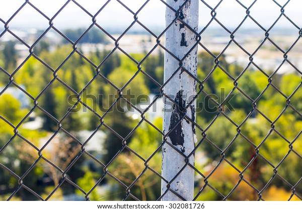 Fence post\
overlooking the suburbs. Selective\
focus