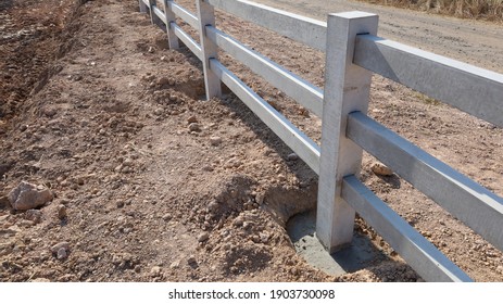 Fence posts and bases. Concrete column base for the stability of the newly built outdoor fence on the ground background and brace road with copy area. Choose content and focus