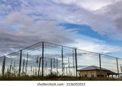 fence in a water catchment against a blue sky background