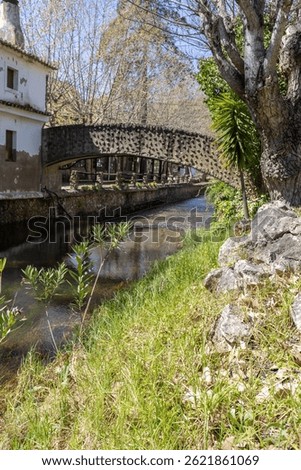 A fenced spring, a historic site that occasionally becomes a swimming pool. Old walls of the Praia Fluvial de Alte, in the Algarve, Portugal