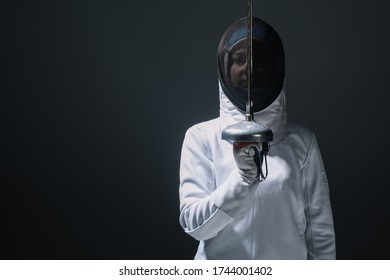 Fencer Holding Rapier Near Fencing Mask Isolated On Black