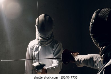 Fencer woman with fencing sword. Fencers duel concept. - Powered by Shutterstock