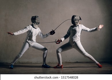 Fencer woman with fencing sword. Fencers duel concept.