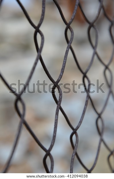 Fencing corporate property in the city. Industrial\
Zone. Protection against thieves. Safety. Iron element. Blurred\
background warehouse. Old\
fence.