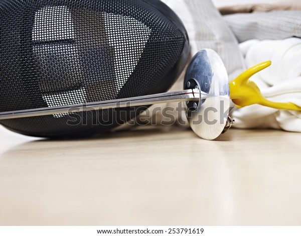 fencing mask and rapier on
floor.