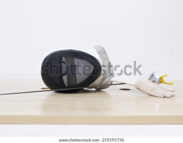 fencing mask and rapier on\
floor.