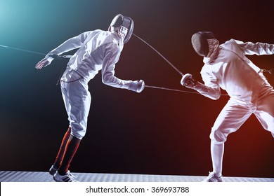 Fencing players isolated on black background